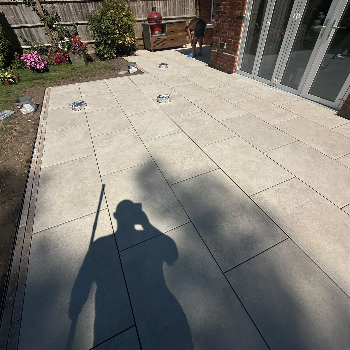 Large porcelain patio with brick edging installed by Reynolds Garden & Paving in Leicester
